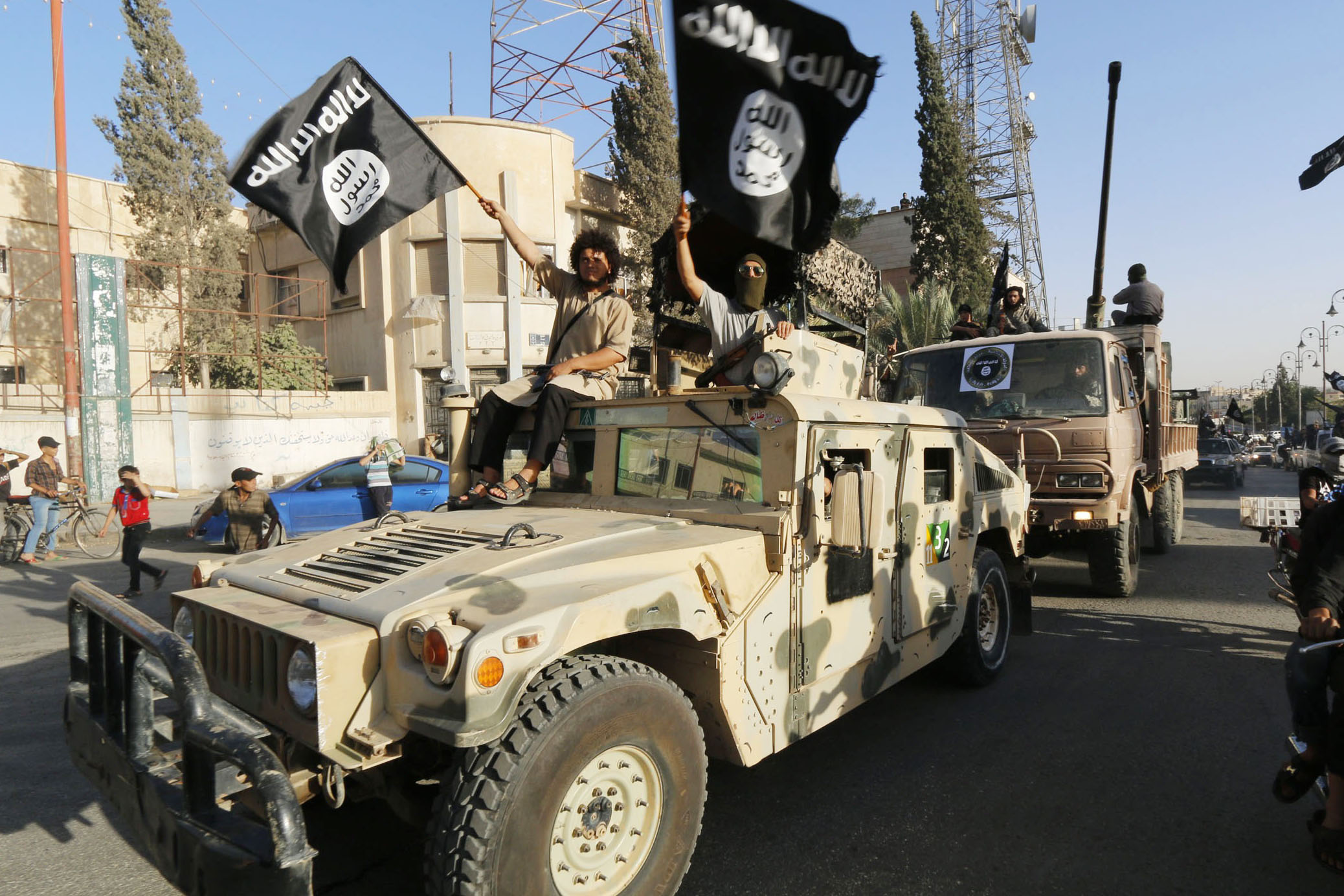 Militant Islamist fighters take part in a military parade along the streets of Syria's northern Raqqa province