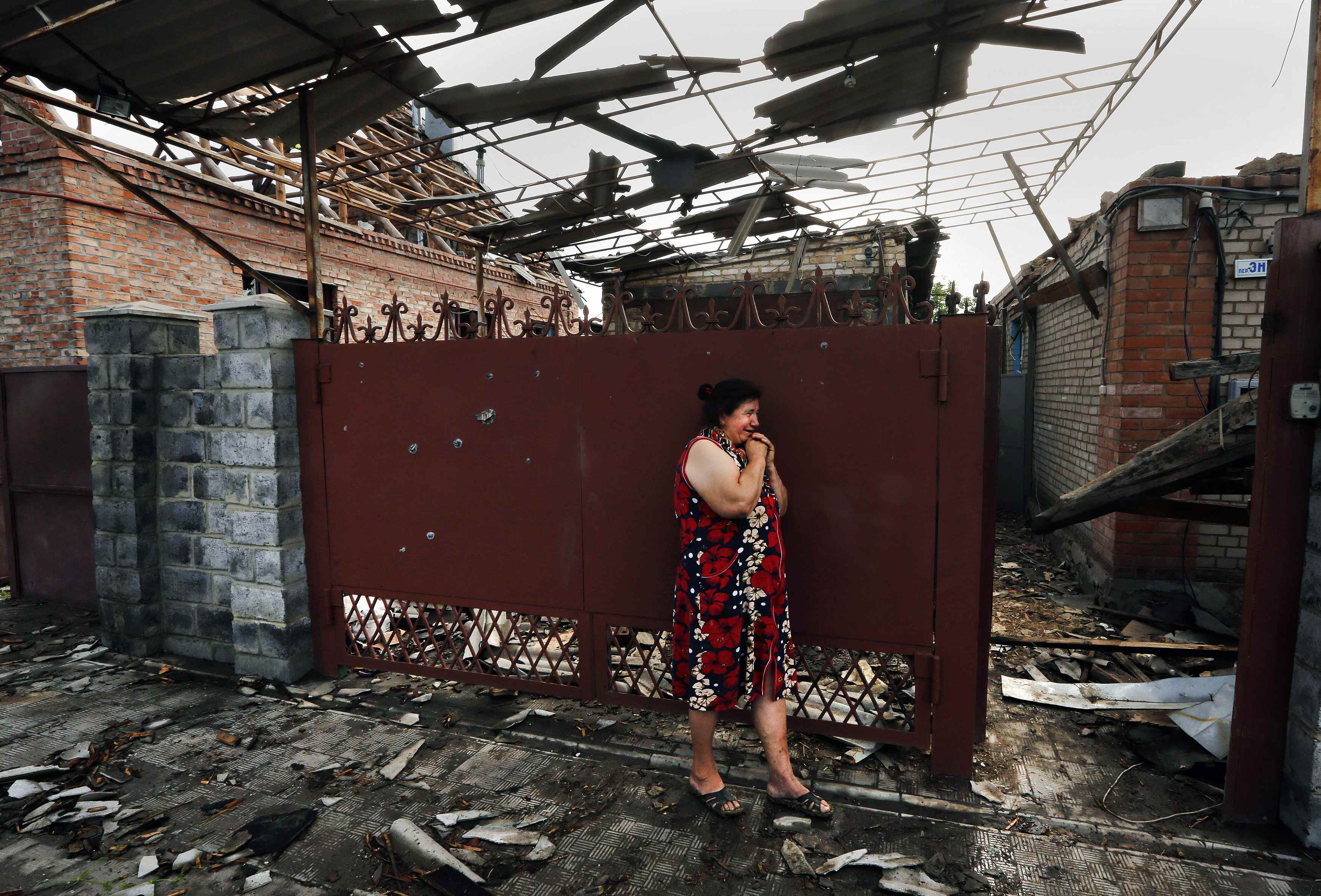 Yekaterina Len, 61, cries outside her destroyed house following what locals say was overnight shelling by Ukrainian forces, in Slaviansk